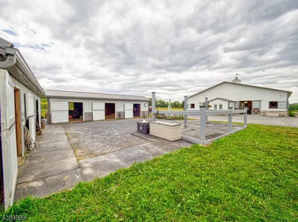 a kitchen with granite countertop a stove a sink a dining table and chairs with wooden floor