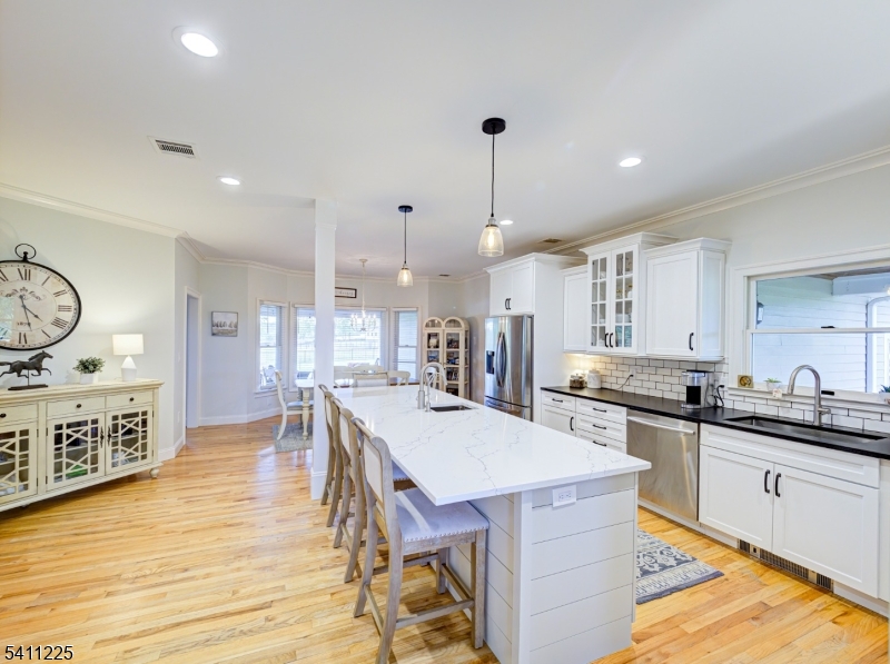 33 Kappus Road Milford, NJ 08848 - Photo 29 of 50 a kitchen with granite countertop a stove a sink a dining table and chairs with wooden floor