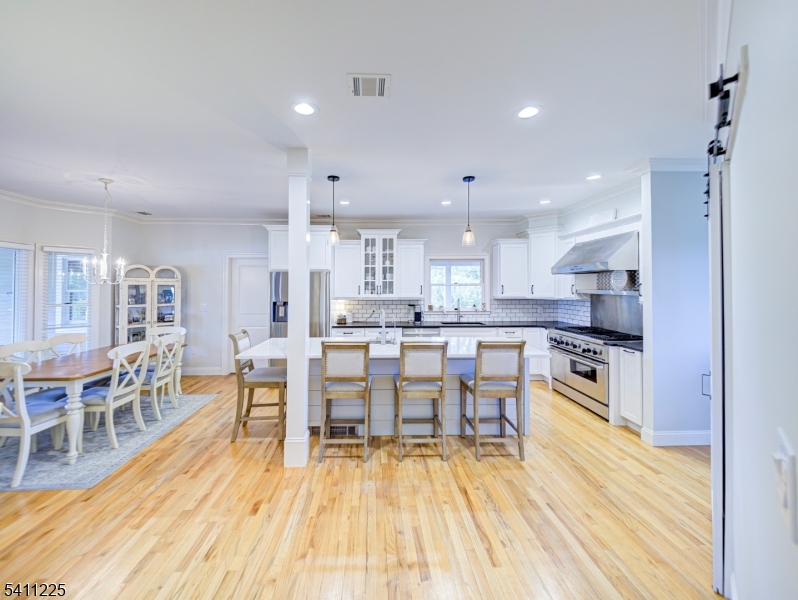 33 Kappus Road Milford, NJ 08848 - Photo 30 of 50 a kitchen with stainless steel appliances granite countertop a stove top oven a sink dishwasher white cabinets and a dining table with wooden floor