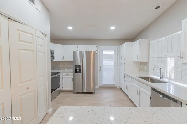 a kitchen with granite countertop a sink and cabinets