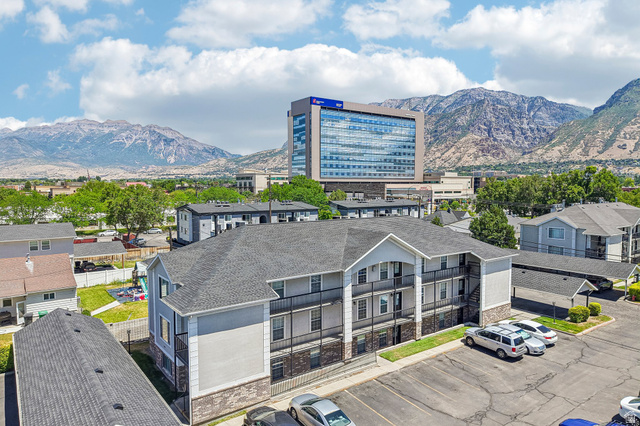 888 600 West, Unit 40 Provo, UT 84604 - Photo 1 of 19 Multi-story residential building featuring a light gray and dark brick exterior, private balconies, and a paved parking area