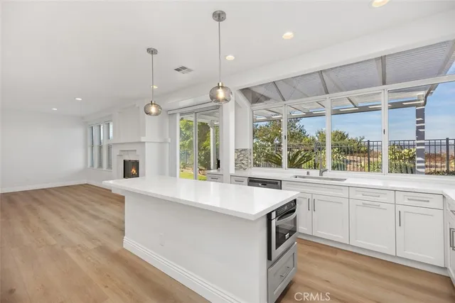 a large kitchen with kitchen island a large counter top space a sink stainless steel appliances and cabinets