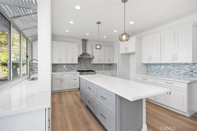 a kitchen with a white center island a sink stainless steel appliances and cabinets