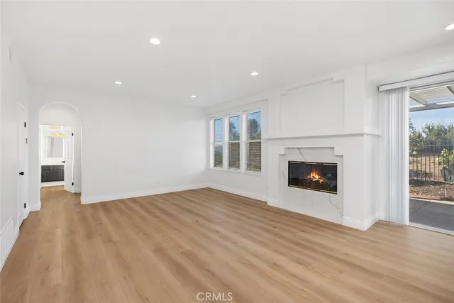a view of empty room with wooden floor and fireplace