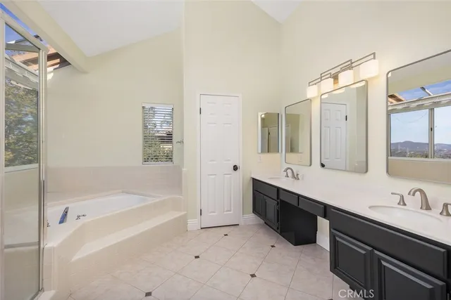 a spacious bathroom with a tub sink shower and mirror