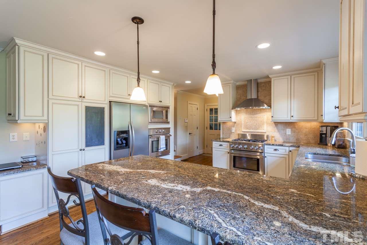 1701 Hunting Ridge Road Raleigh, NC 27615 - Photo 4 of 4 a kitchen with kitchen island granite countertop wooden floor cabinets and appliances