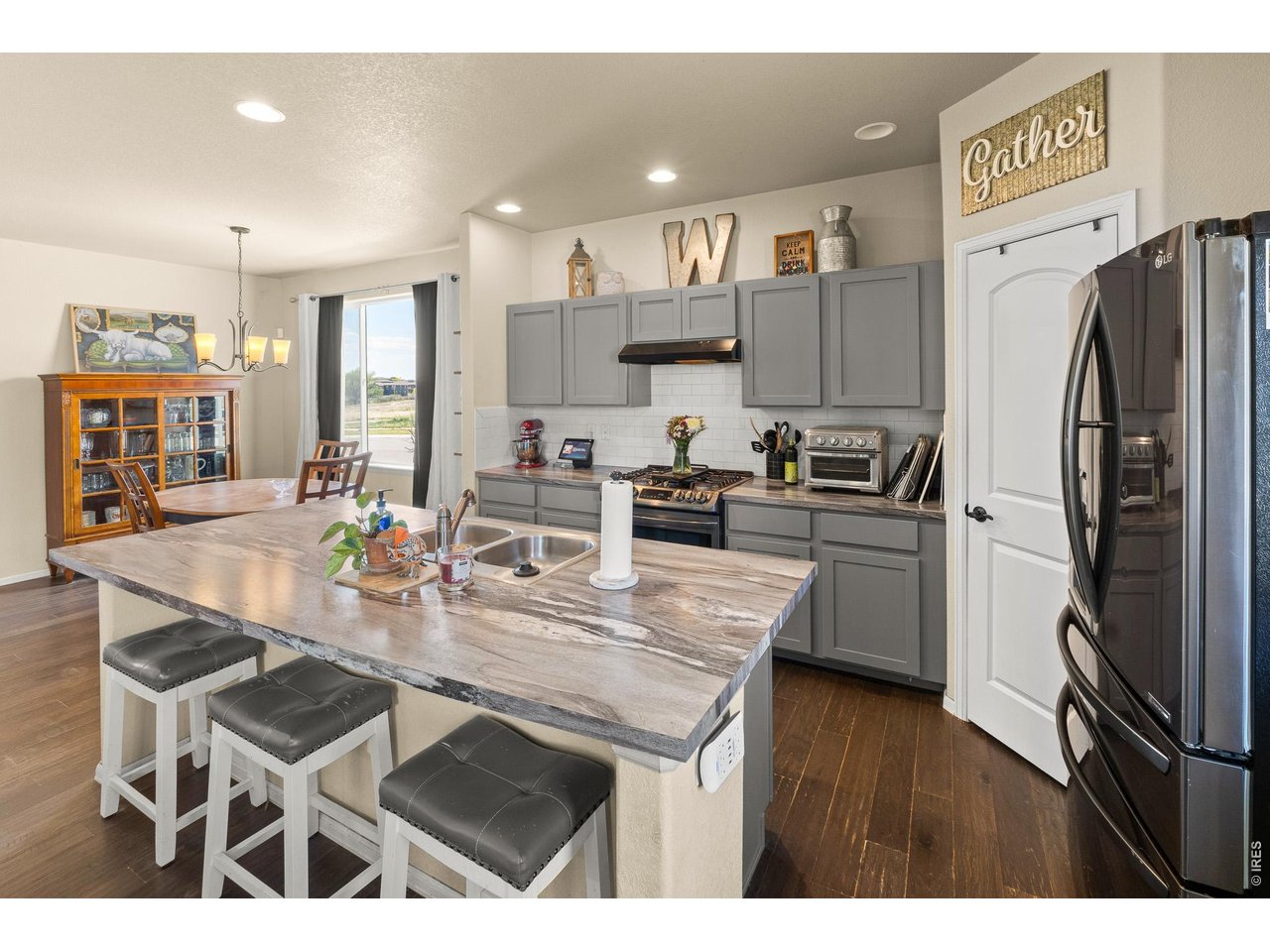 8847 16th St Road Greeley, CO 80634 - Photo 15 of 38 a kitchen with stainless steel appliances kitchen island granite countertop a sink refrigerator and cabinets