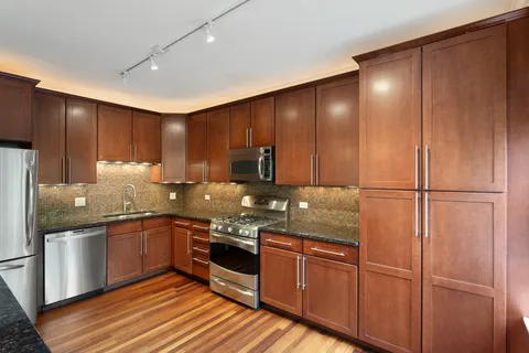 a kitchen with stainless steel appliances granite countertop wooden cabinets a sink and dishwasher