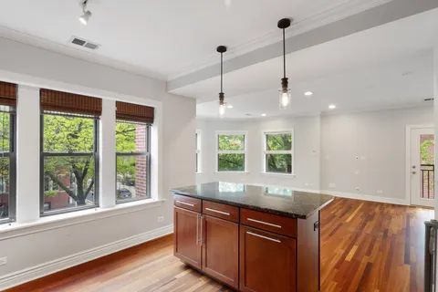 a kitchen with kitchen island large windows and a chandelier