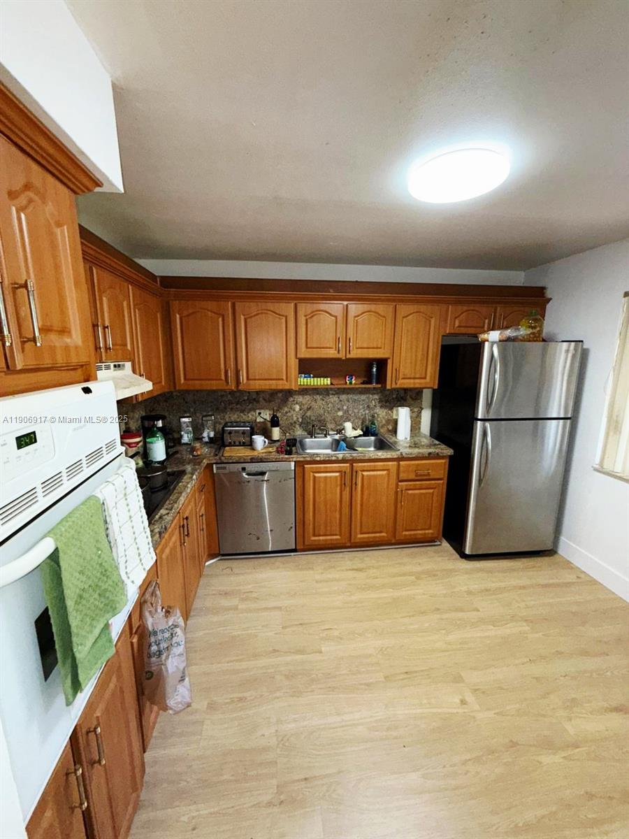 440 Lakeview Drive, Unit 102 Weston, FL 33326 - Photo 3 of 19 a kitchen with stainless steel appliances granite countertop a refrigerator a stove a sink and a microwave