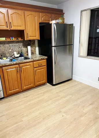 a kitchen with stainless steel appliances granite countertop a refrigerator a sink and dishwasher