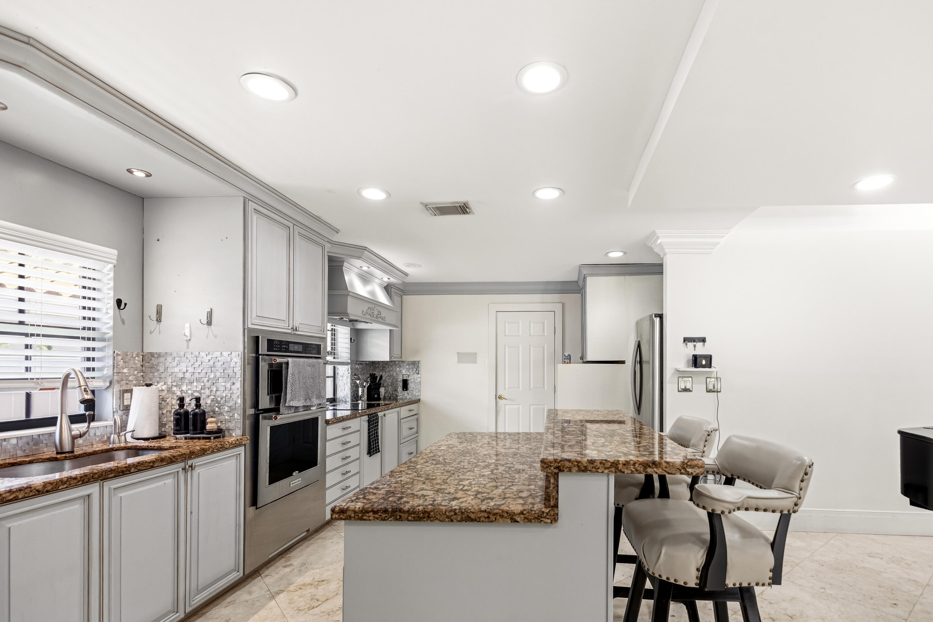 5223 Deerhurst Crescent Circle Boca Raton, FL 33486 - Photo 25 of 51 a kitchen with stainless steel appliances granite countertop a sink refrigerator and cabinets