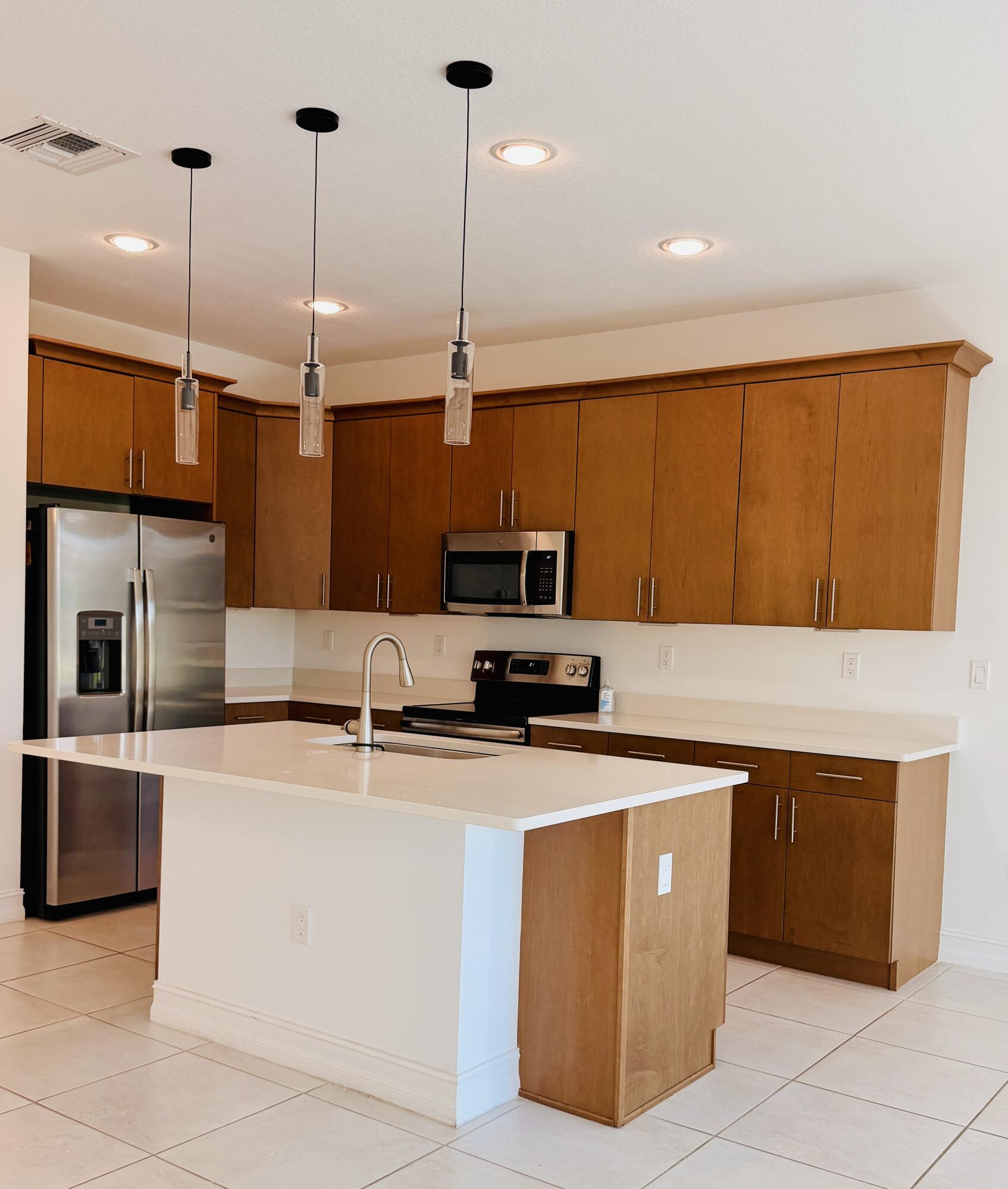 9952 Brickhill Drive Boca Raton, FL 33428 - Photo 2 of 24 a kitchen with stainless steel appliances granite countertop a sink counter space cabinets and a wooden floor