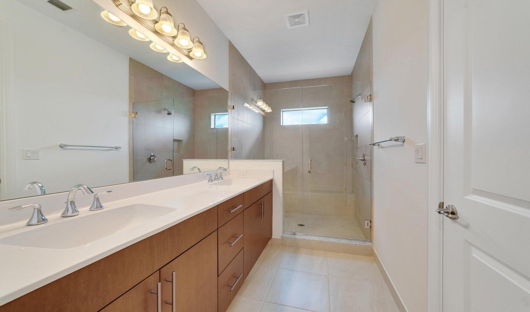 9952 Brickhill Drive Boca Raton, FL 33428 - Photo 10 of 24 a bathroom with a double vanity sink and a mirror