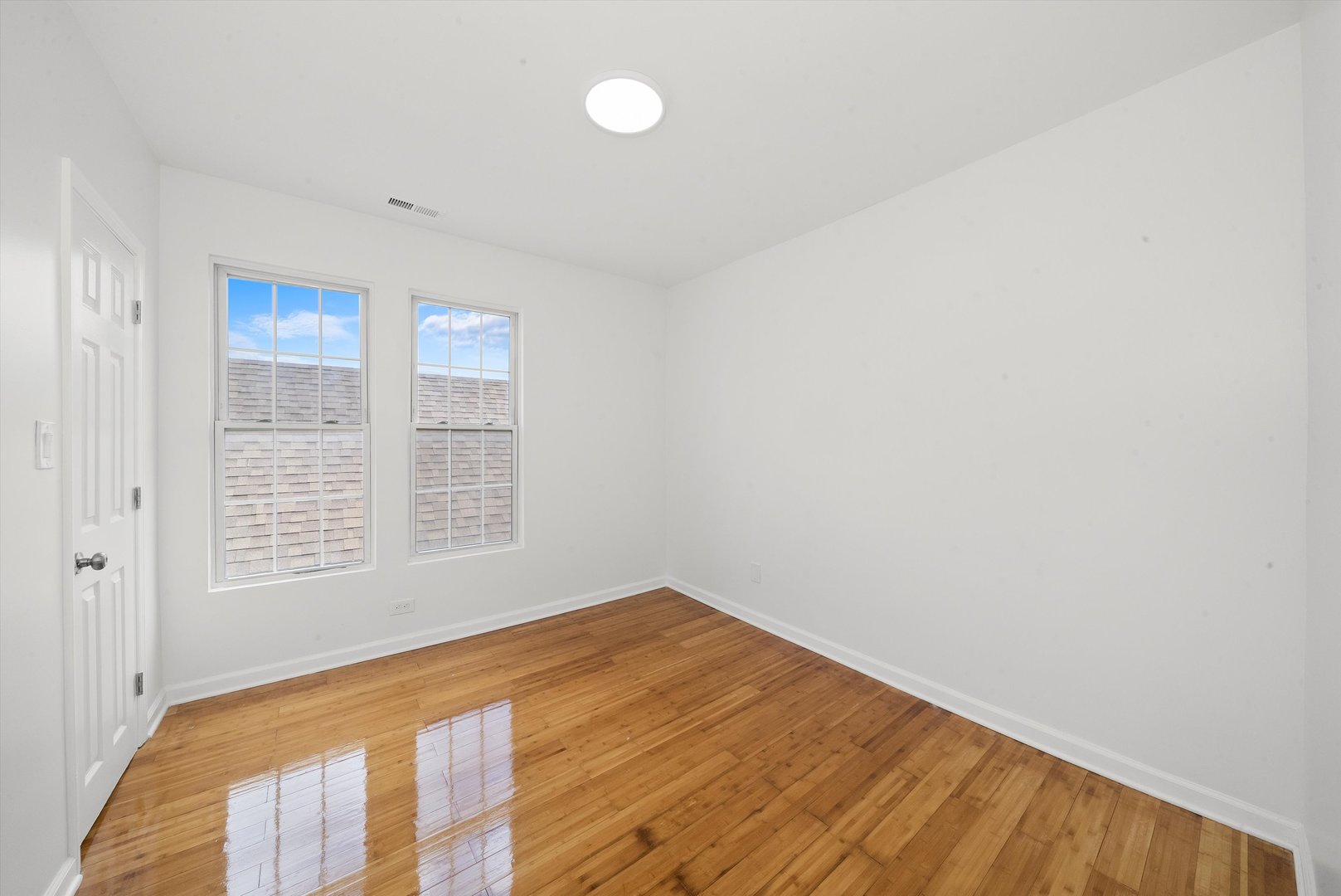 3343 West 59th Place, Unit 2 Chicago, IL 60629 - Photo 7 of 10 a view of an empty room with wooden floor and a window