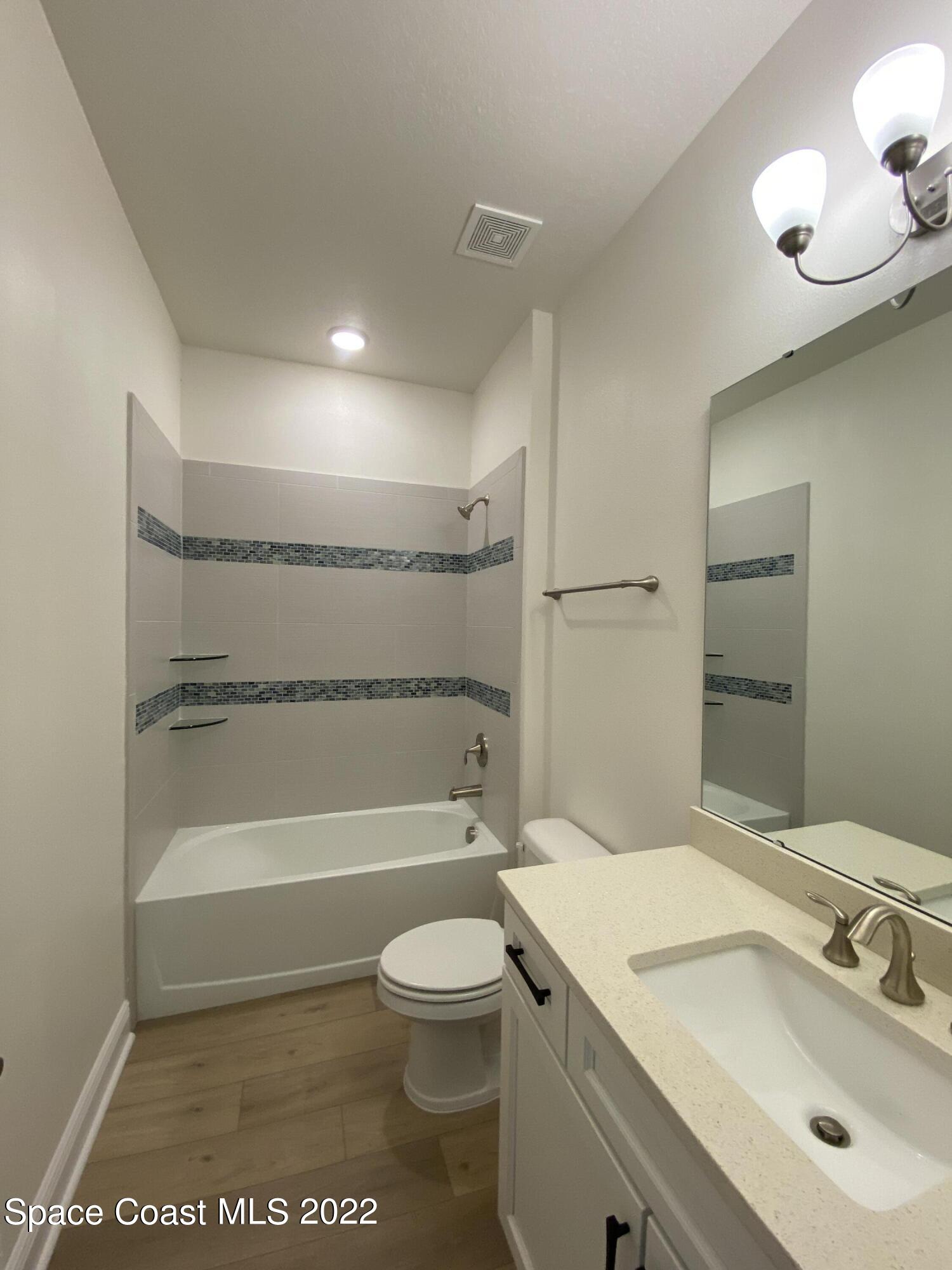 1493 Killian Drive Palm Bay, FL 32905 - Photo 11 of 20 a bathroom with a sink a toilet and shower