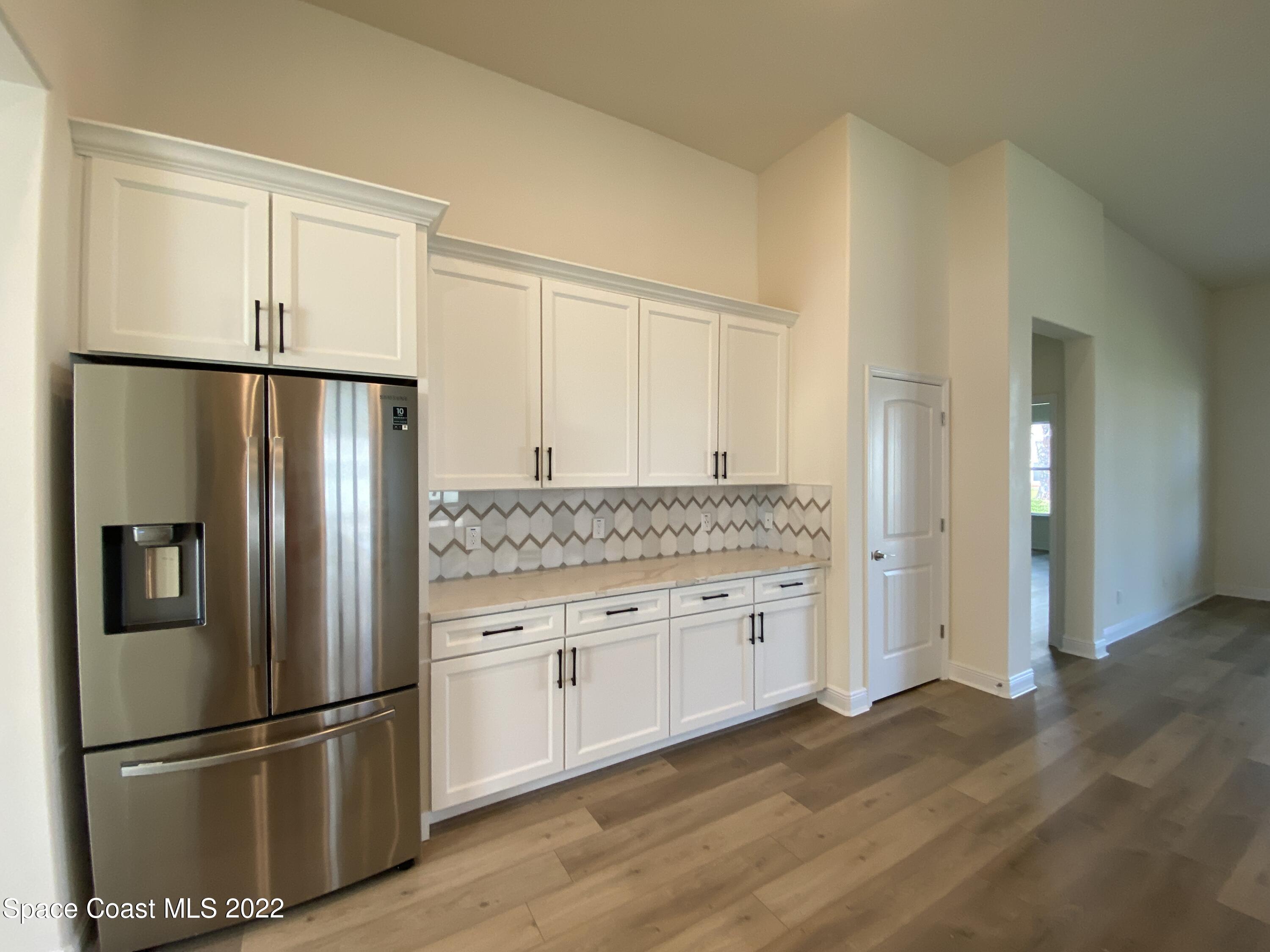 1493 Killian Drive Palm Bay, FL 32905 - Photo 3 of 20 a kitchen with stainless steel appliances granite countertop a refrigerator and a sink