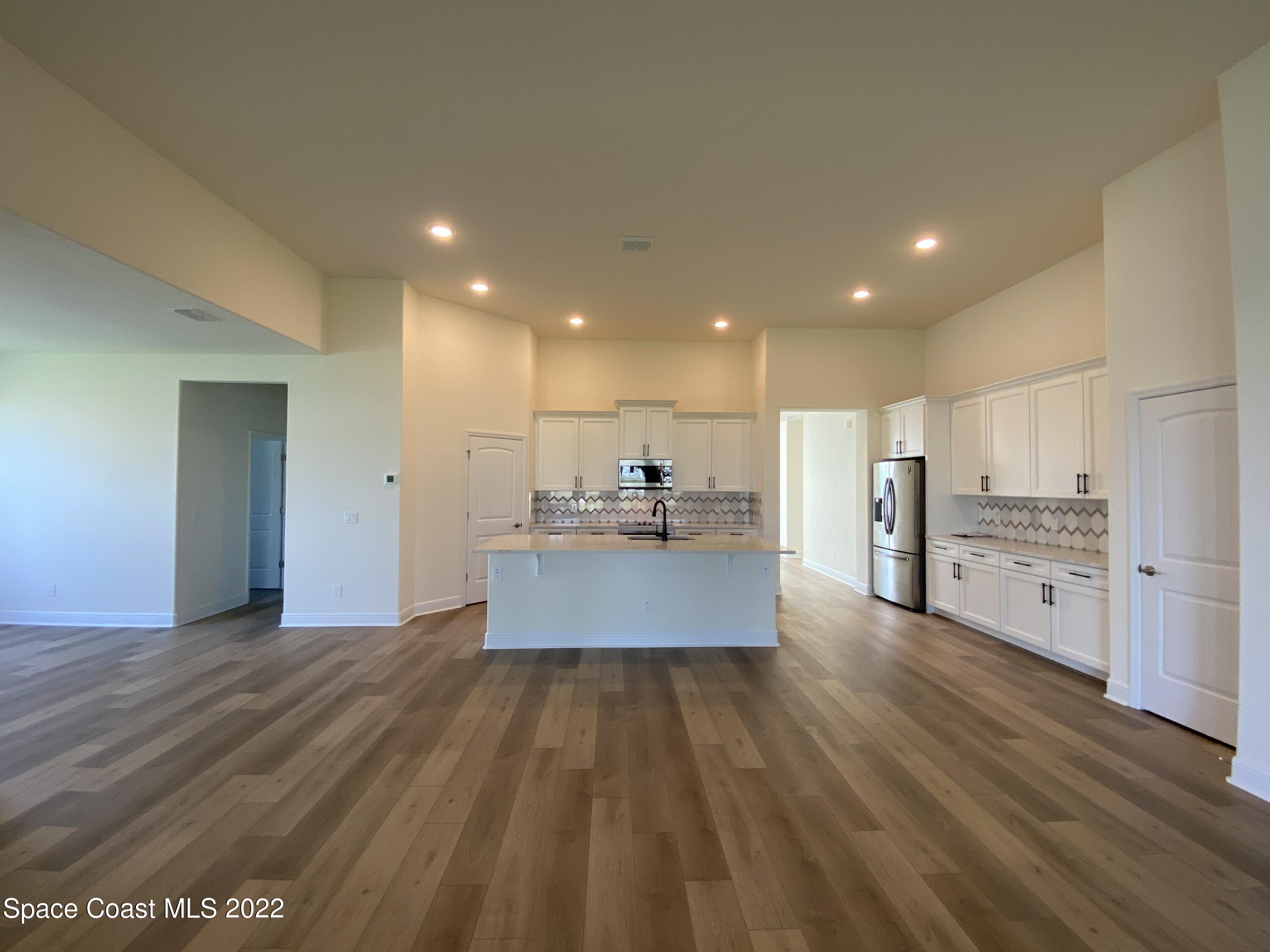 1493 Killian Drive Palm Bay, FL 32905 - Photo 7 of 20 a large kitchen with kitchen island a sink a stove and a refrigerator