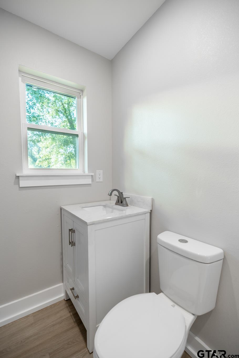 2922 West Azalea Drive Tyler, TX 75701 - Photo 29 of 39 a bathroom with a toilet a sink and a window