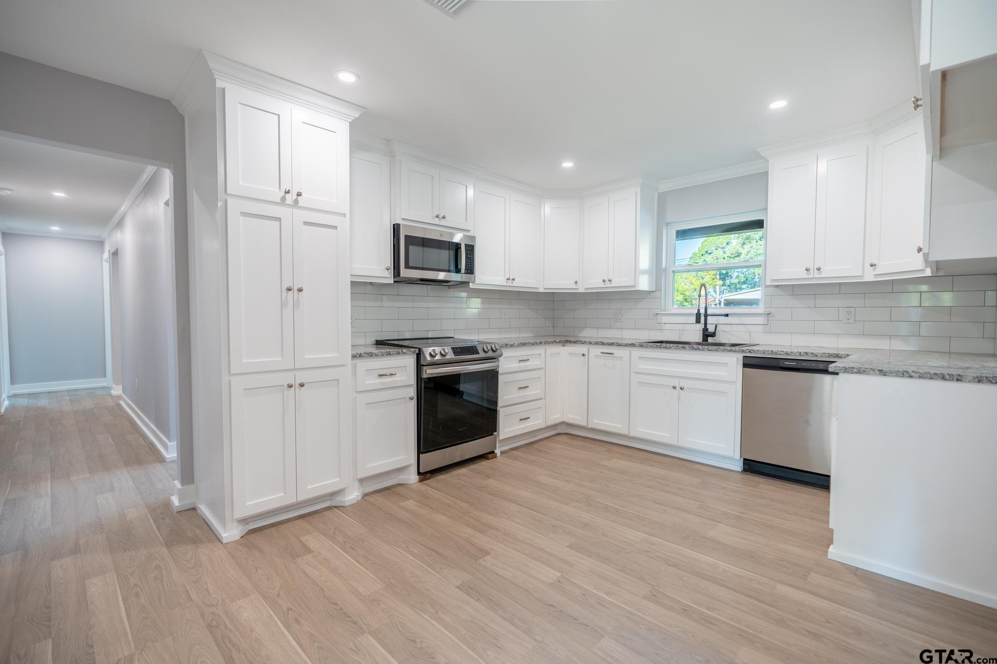 2922 West Azalea Drive Tyler, TX 75701 - Photo 7 of 39 a kitchen with white cabinets stainless steel appliances and a window