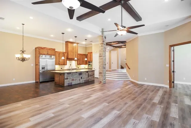 a large kitchen with a lot of counter space and a ceiling fan