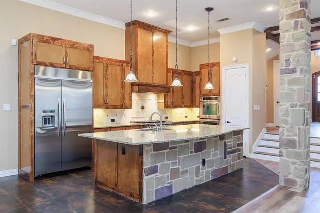 a kitchen with stainless steel appliances granite countertop a sink a refrigerator and a stove