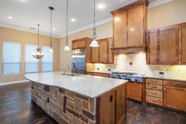 a kitchen with stainless steel appliances granite countertop a sink a stove and a refrigerator