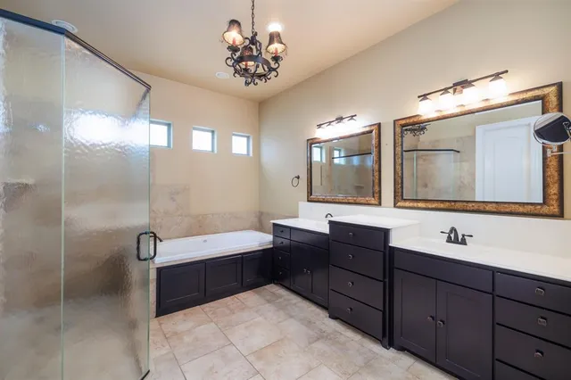 a bathroom with a double vanity sink bathtub and a mirror