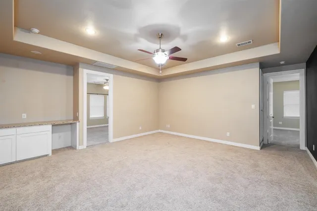 an empty room with closet and a ceiling fan