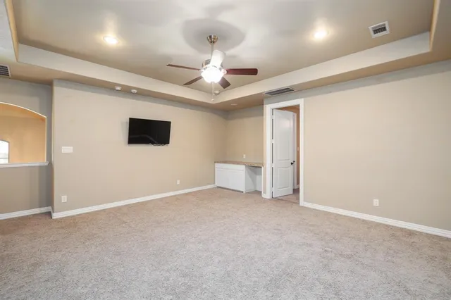 an empty room with fan and windows