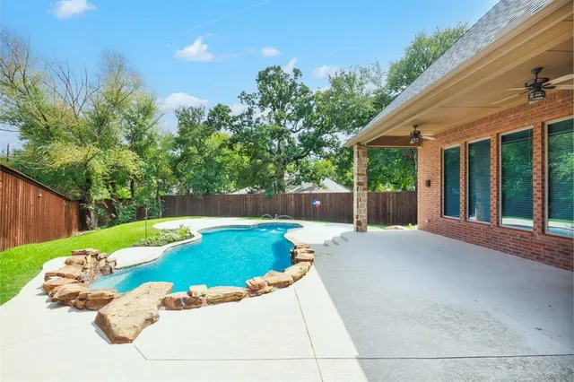 a view of a backyard with table and chairs potted plants with wooden fence