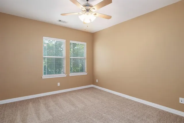 an empty room with a window and a fan
