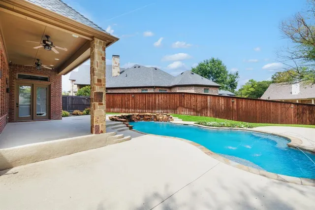 a view of a backyard with a large tree and wooden fence