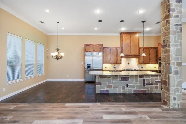 a view of kitchen with stainless steel appliances kitchen island sink stove and living room