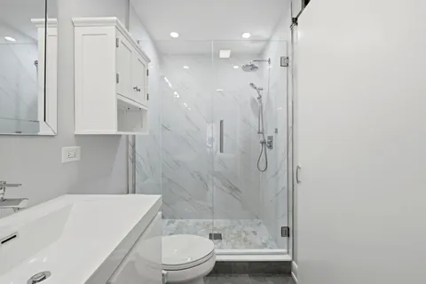 a bathroom with a bathtub shower sink vanity and toilet