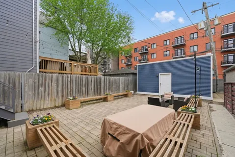 a backyard of a house with wooden floor chairs and wooden fence