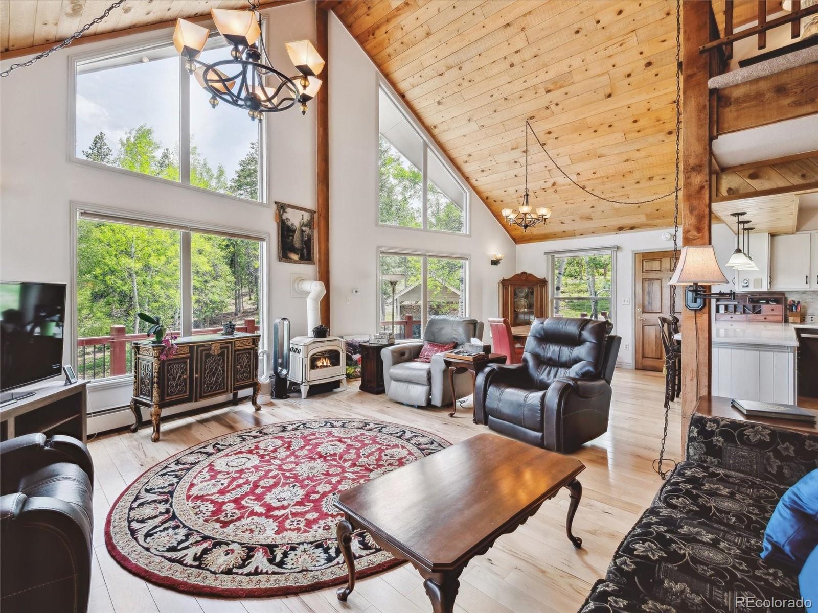 9390 South Warhawk Road Conifer, CO 80433 - Photo 13 of 46 a living room with furniture large window and rug