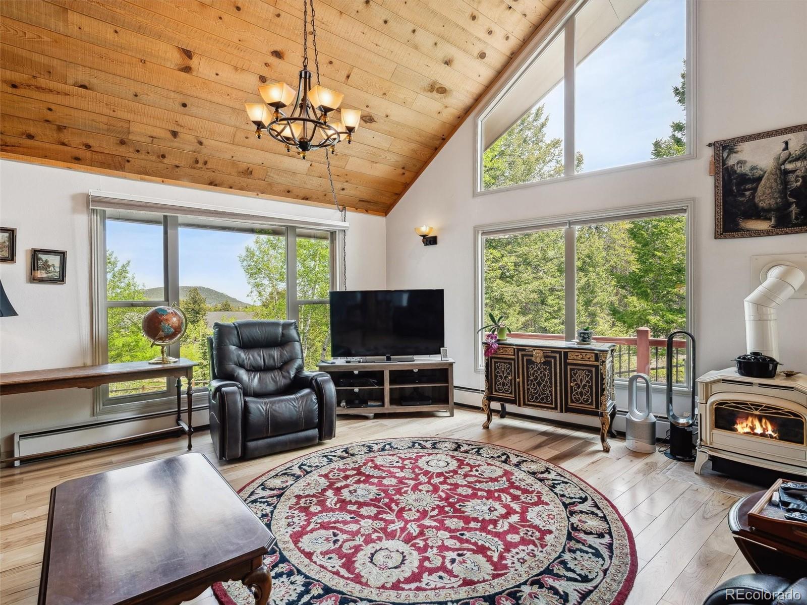 9390 South Warhawk Road Conifer, CO 80433 - Photo 17 of 46 a living room with furniture a flat screen tv and a large window