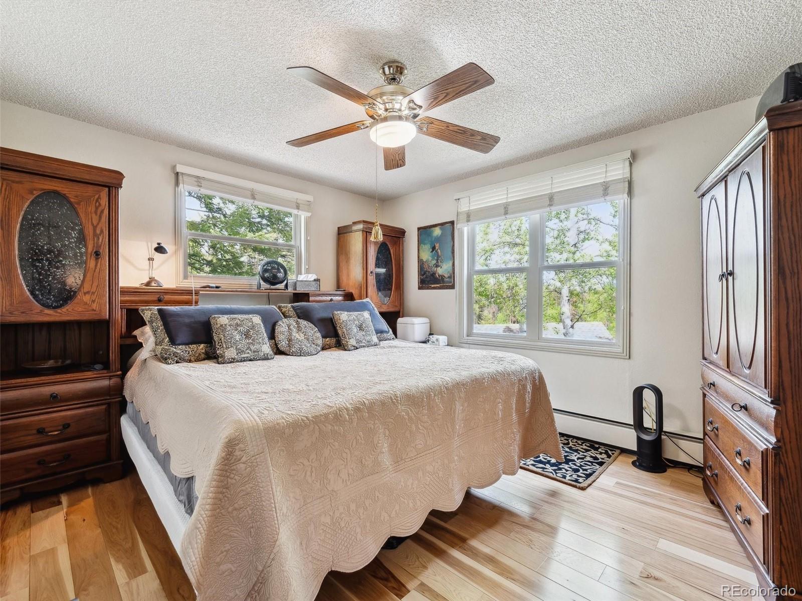 9390 South Warhawk Road Conifer, CO 80433 - Photo 21 of 46 a spacious bedroom with a bed and a large window