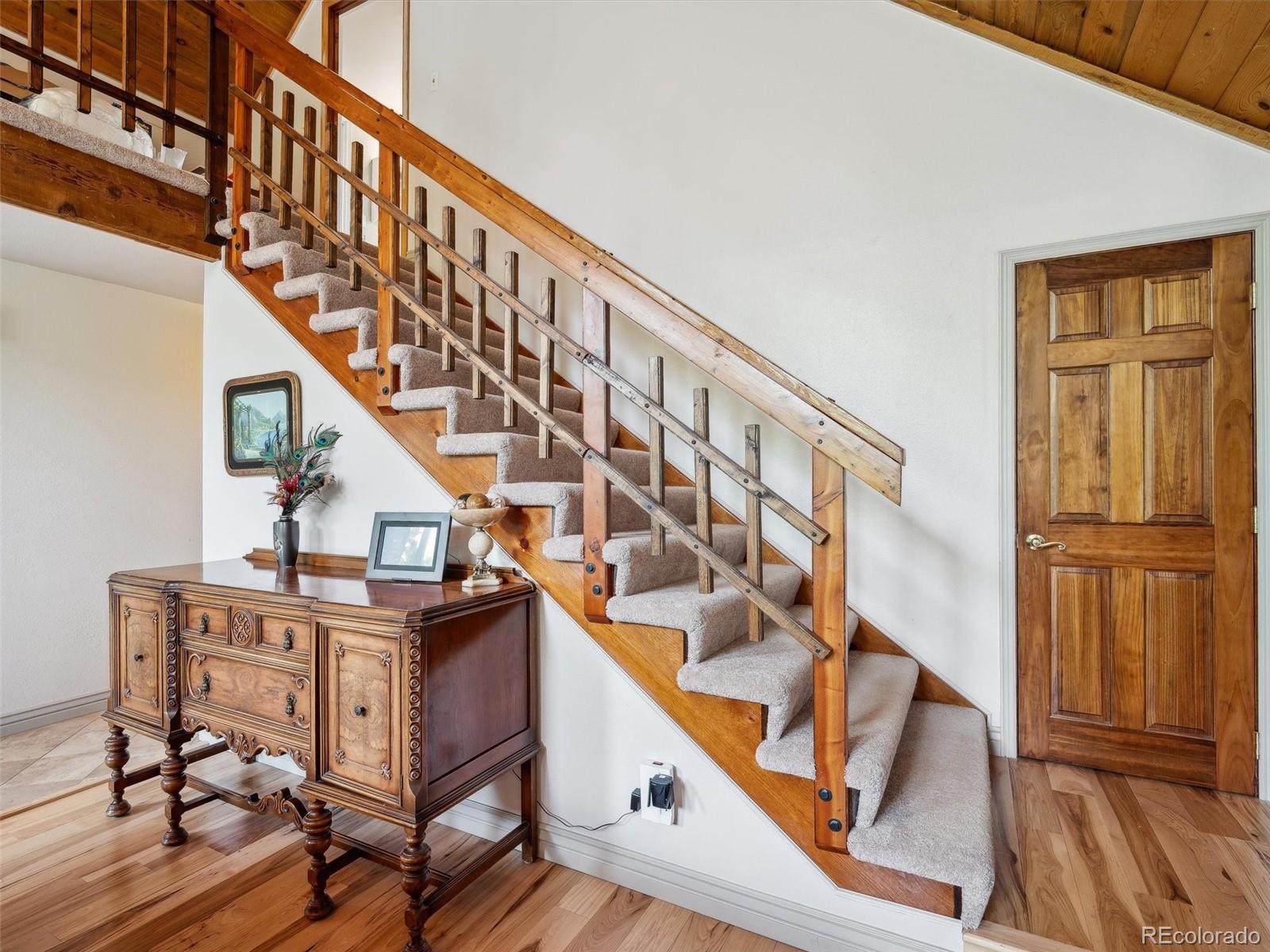 9390 South Warhawk Road Conifer, CO 80433 - Photo 22 of 46 a view of entryway with wooden floor and stairs