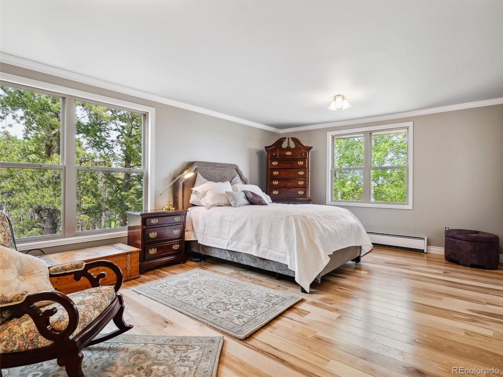 9390 South Warhawk Road Conifer, CO 80433 - Photo 23 of 46 a bed sitting in a bedroom next to a window