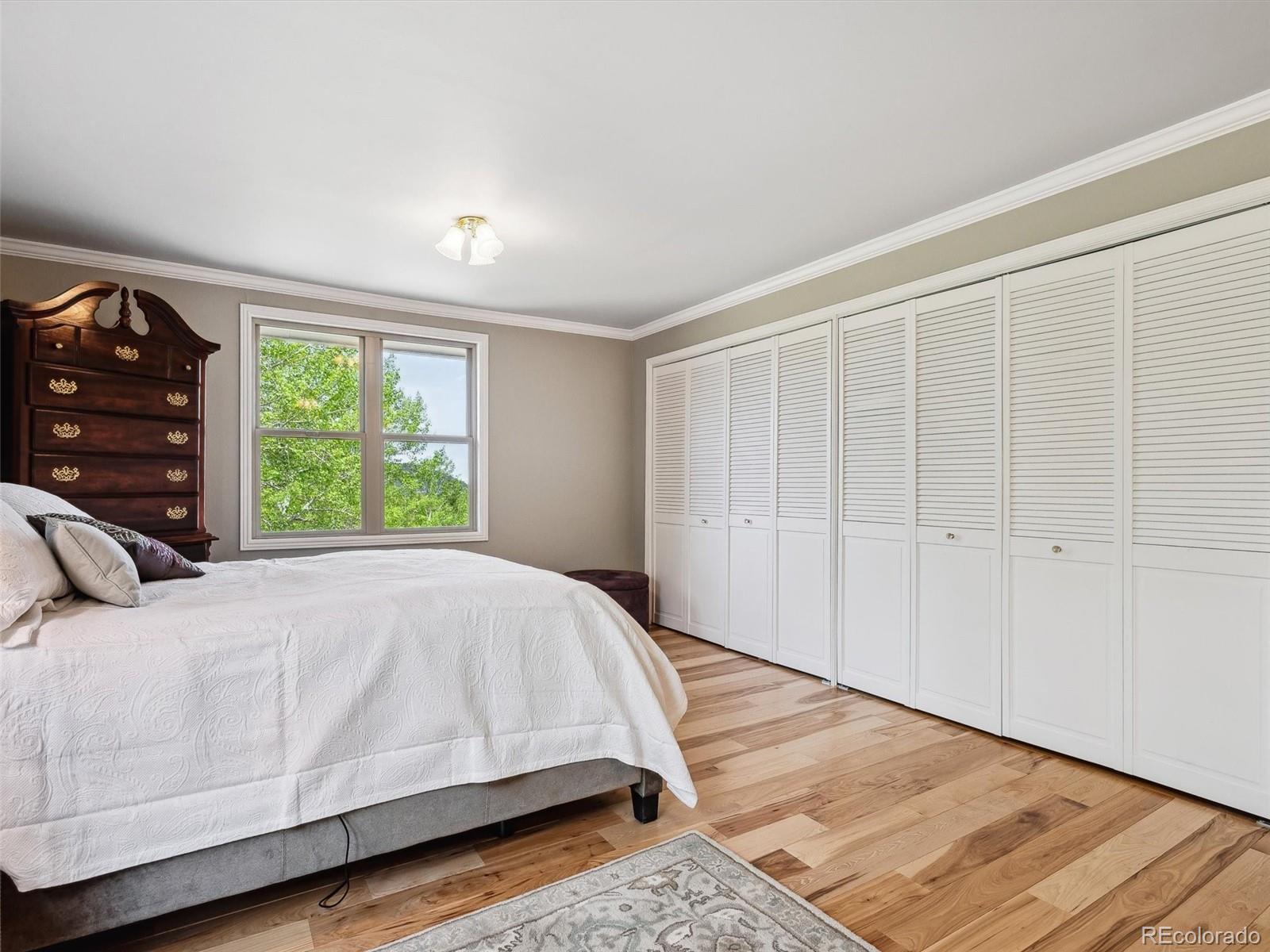 9390 South Warhawk Road Conifer, CO 80433 - Photo 24 of 46 a bed sitting in a bedroom next to a window