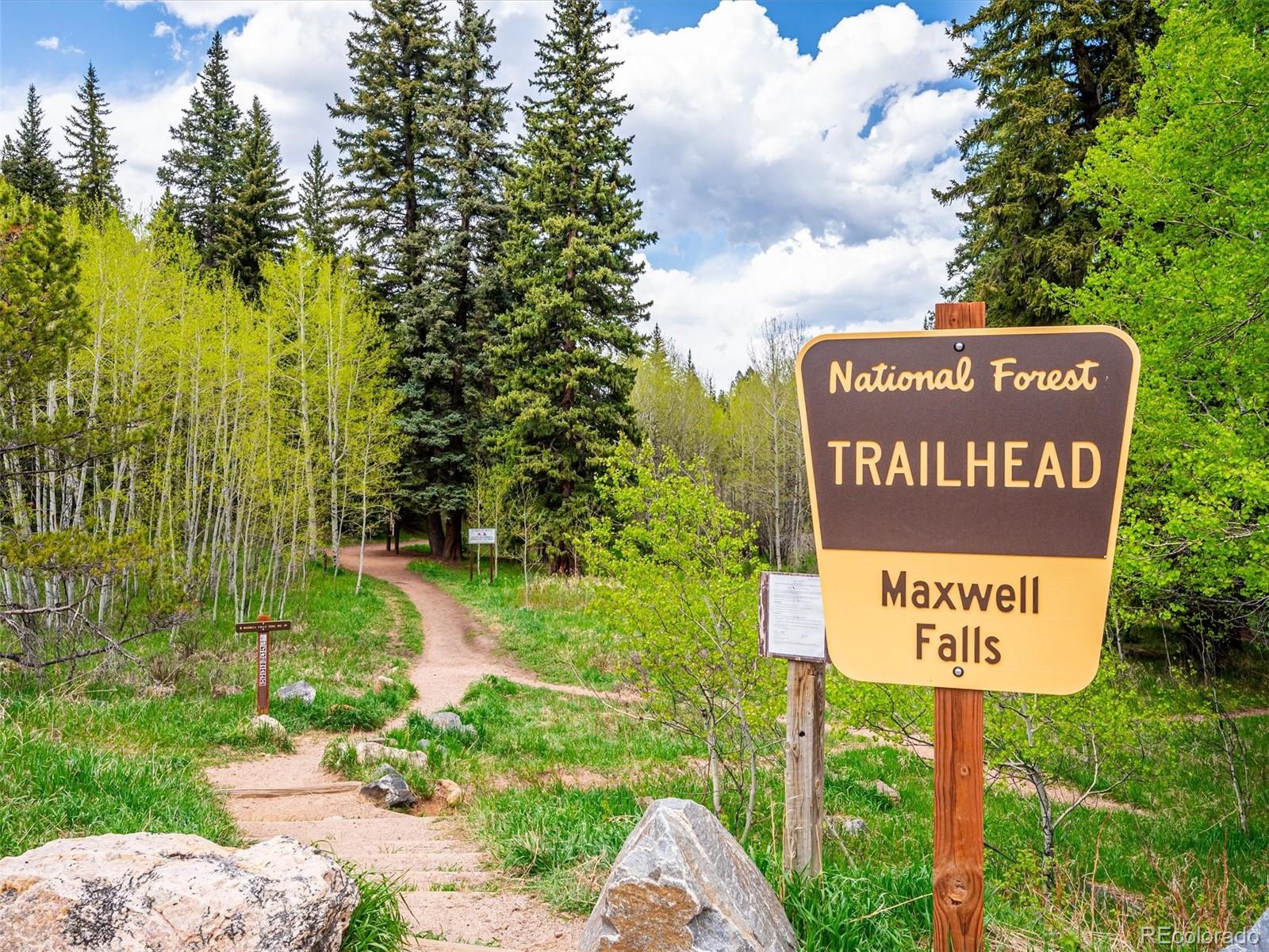 9390 South Warhawk Road Conifer, CO 80433 - Photo 42 of 46 a sign broad in front of the red white house