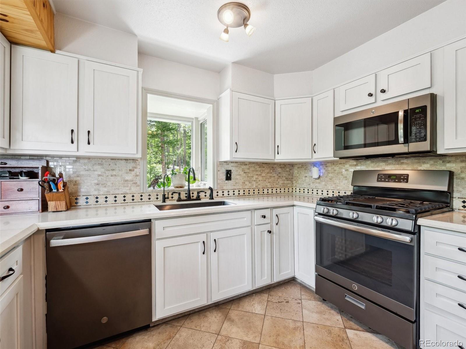 9390 South Warhawk Road Conifer, CO 80433 - Photo 10 of 46 a kitchen with cabinets stainless steel appliances and a sink