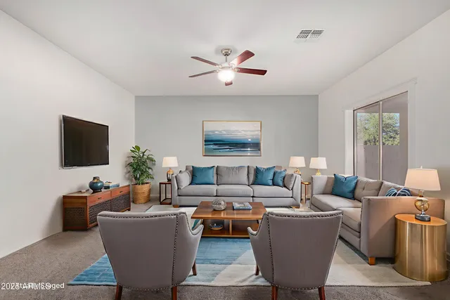 a living room with furniture a flat screen tv and a large window
