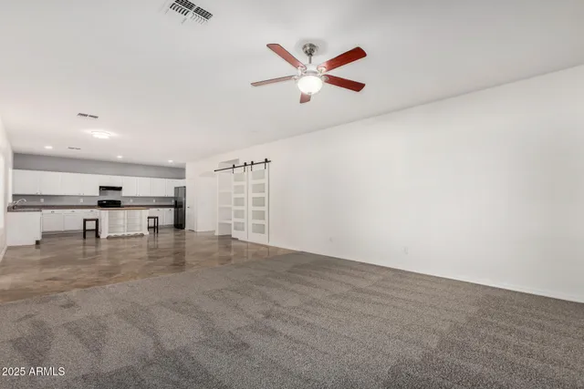 an empty room with cabinet and ceiling fan