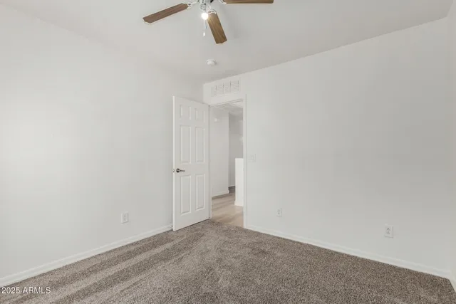 a view of a big room with wooden floor and ceiling fan