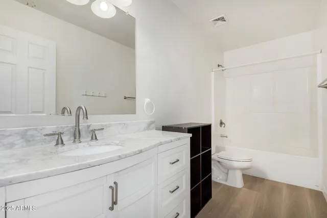 an empty room with a chandelier fan