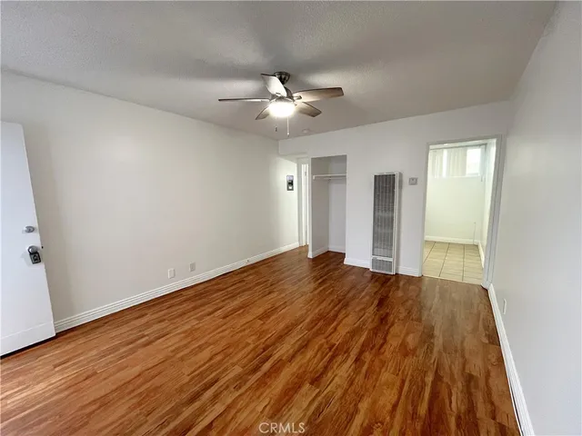 a view of empty room with wooden floor