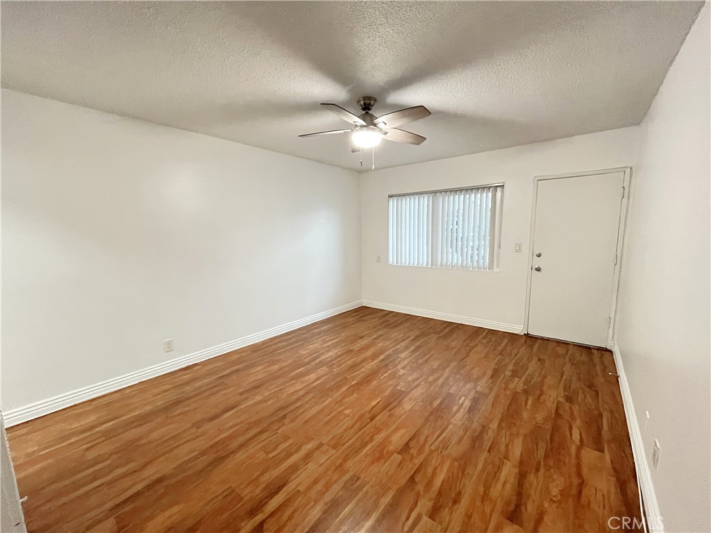 12926 Doty Avenue, Unit 9 Hawthorne, CA 90250 - Photo 5 of 12 an empty room with wooden floor ceiling fan and windows